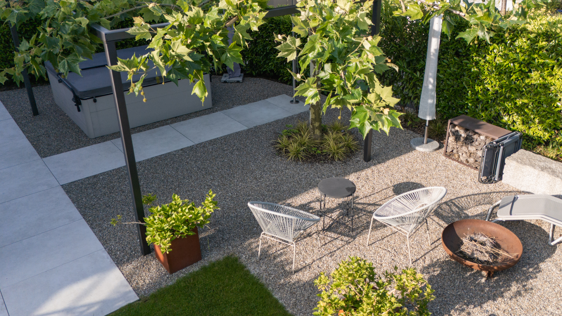 Drohnenaufnahme eines Gartens mit Plattane als Schattengeber für eine gemütliche Gartenecke mit Feuerschale. 