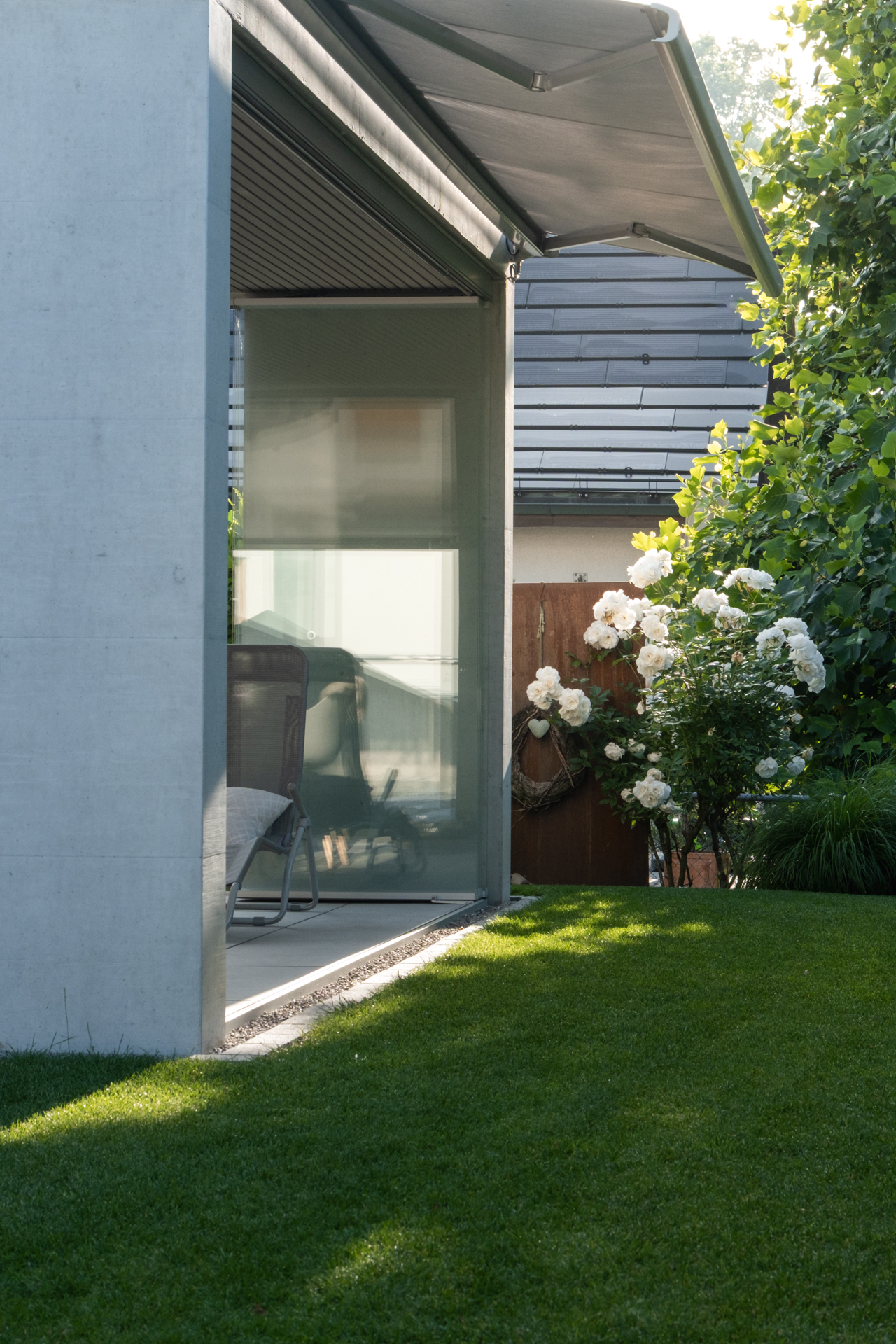Loggia mit Glas Fronten und viel grüner Wiese. 