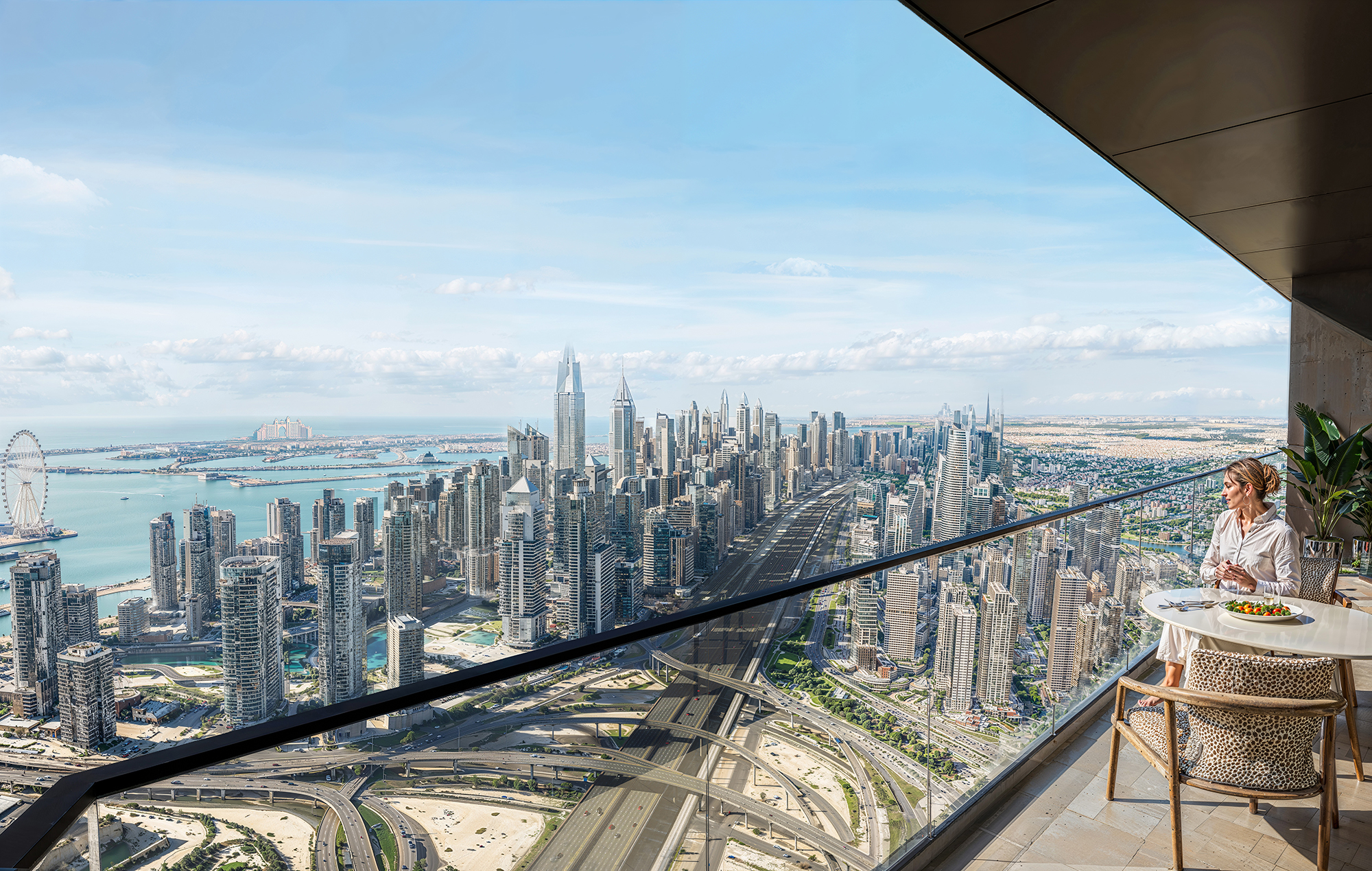 Luxury high-rise balcony view at Sobha Central overlooking Dubai Marina skyline, Sheikh Zayed Road, and the Arabian Gulf.