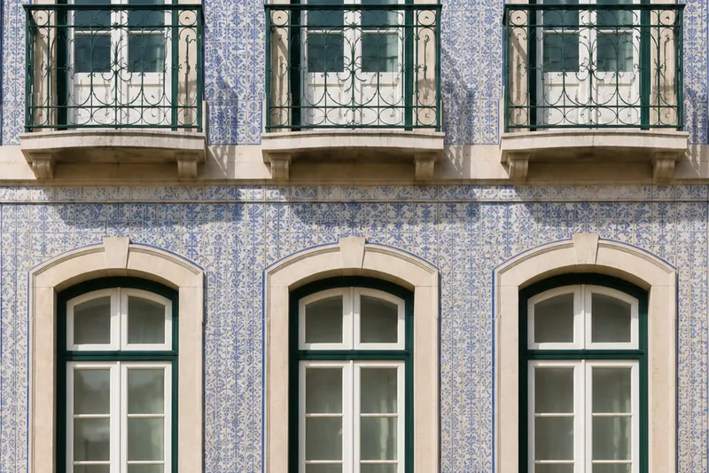 Fachada do edifício de Santos — Guarda Mor, com azulejos azuis e brancos, janelas em arco e varandas de ferro.