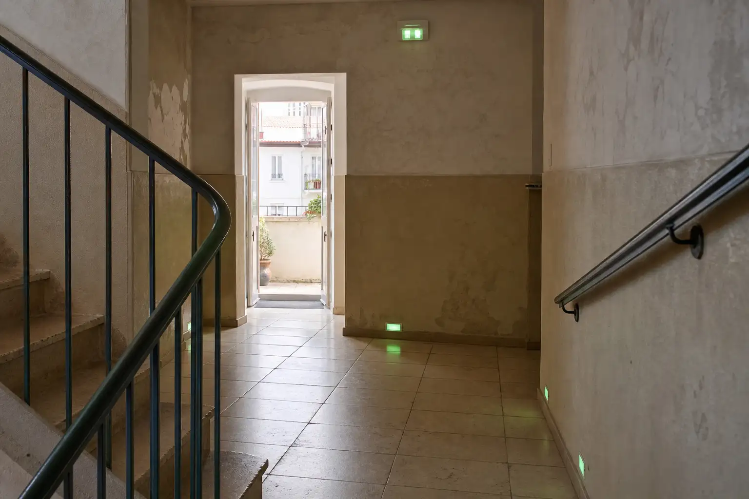 Patamar de escadas de condomínio com percurso de evacuação livre e sinalização de segurança discreta