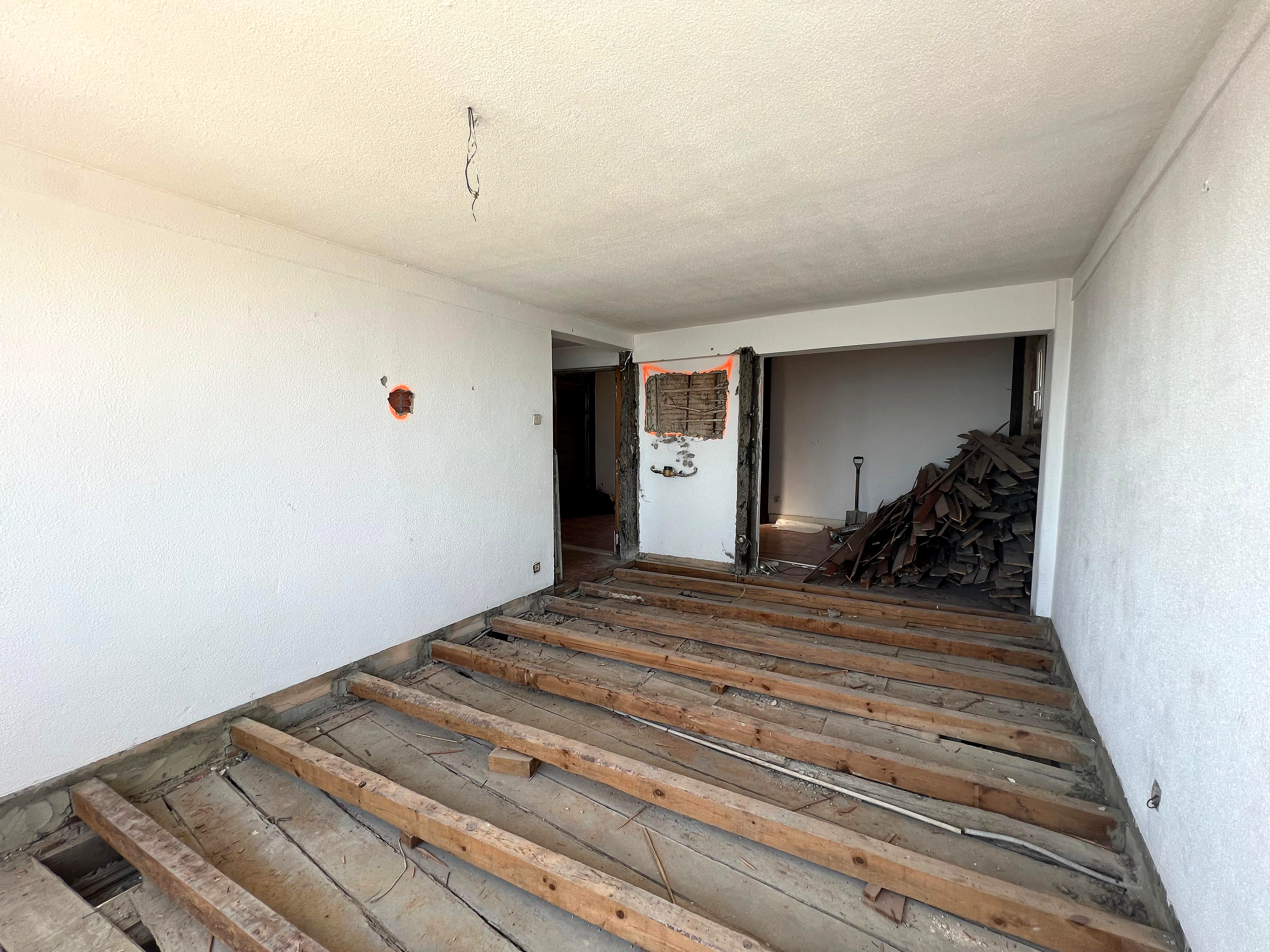 Antes: divisão em obra com vigamentos de pavimento expostos e madeiras removidas