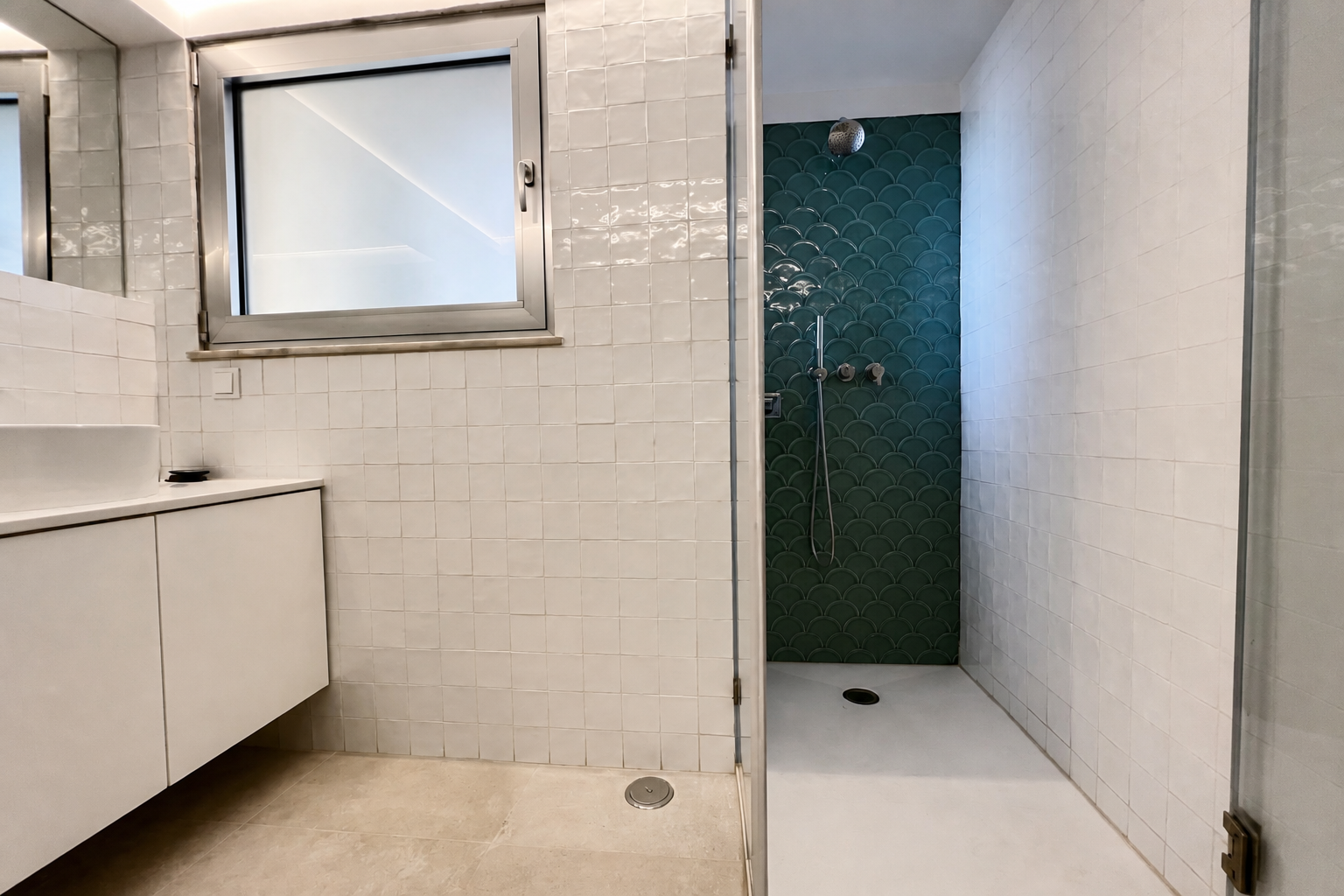 Depois: casa de banho renovada com azulejos brancos, duche e parede de escama verde