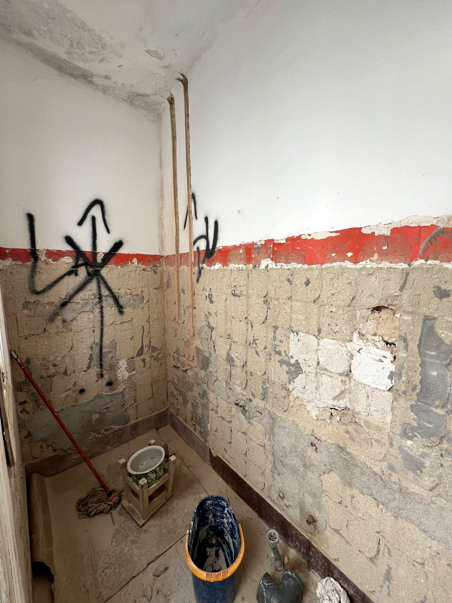 Antes: instalação sanitária desmontada com revestimentos removidos e canalizações expostas