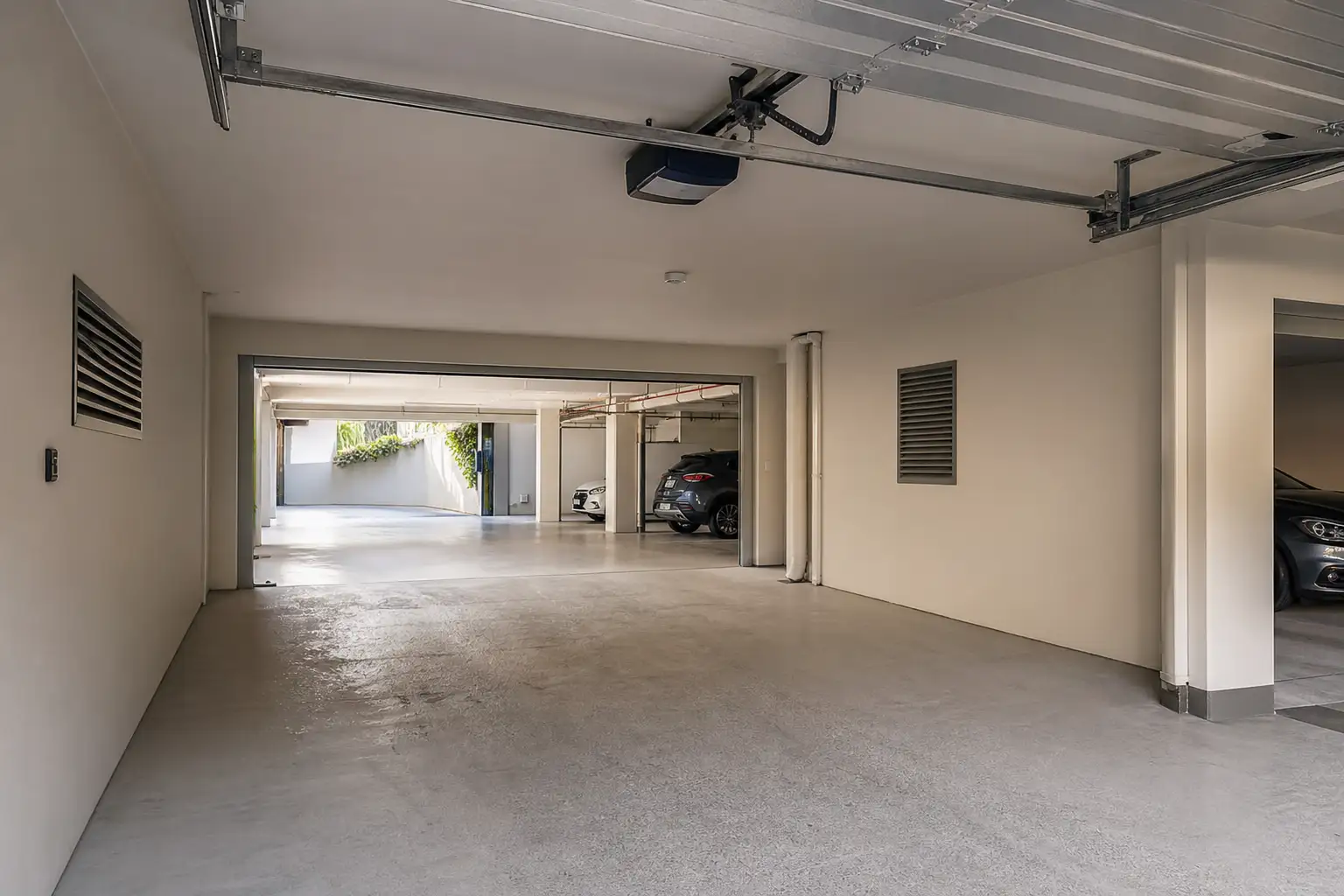 Calhas e automatismo de porta seccionada no interior de uma garagem de condomínio