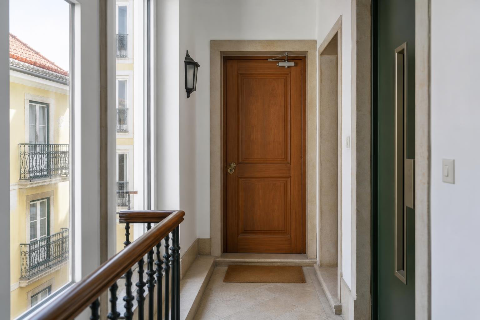 Corredor de edifício residencial com porta de acesso equipada com fecho hidráulico discreto.