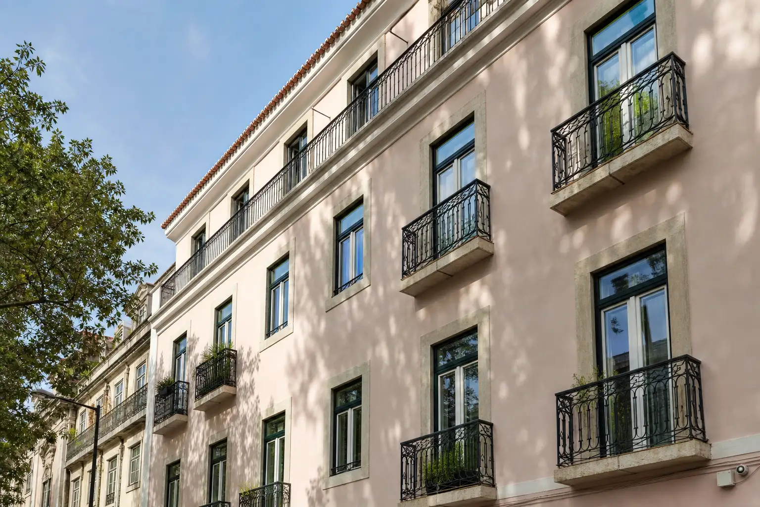 Fachada residencial de Lisboa com janelas renovadas e sombreamento exterior discreto