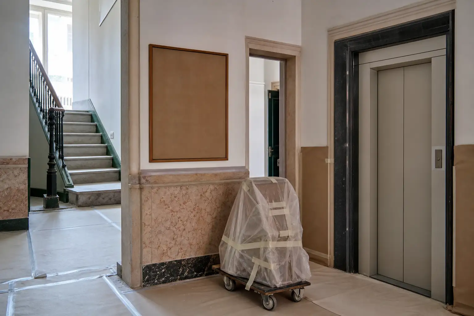 Entrada de prédio residencial em Lisboa protegida para uma obra de remodelação durante o dia.