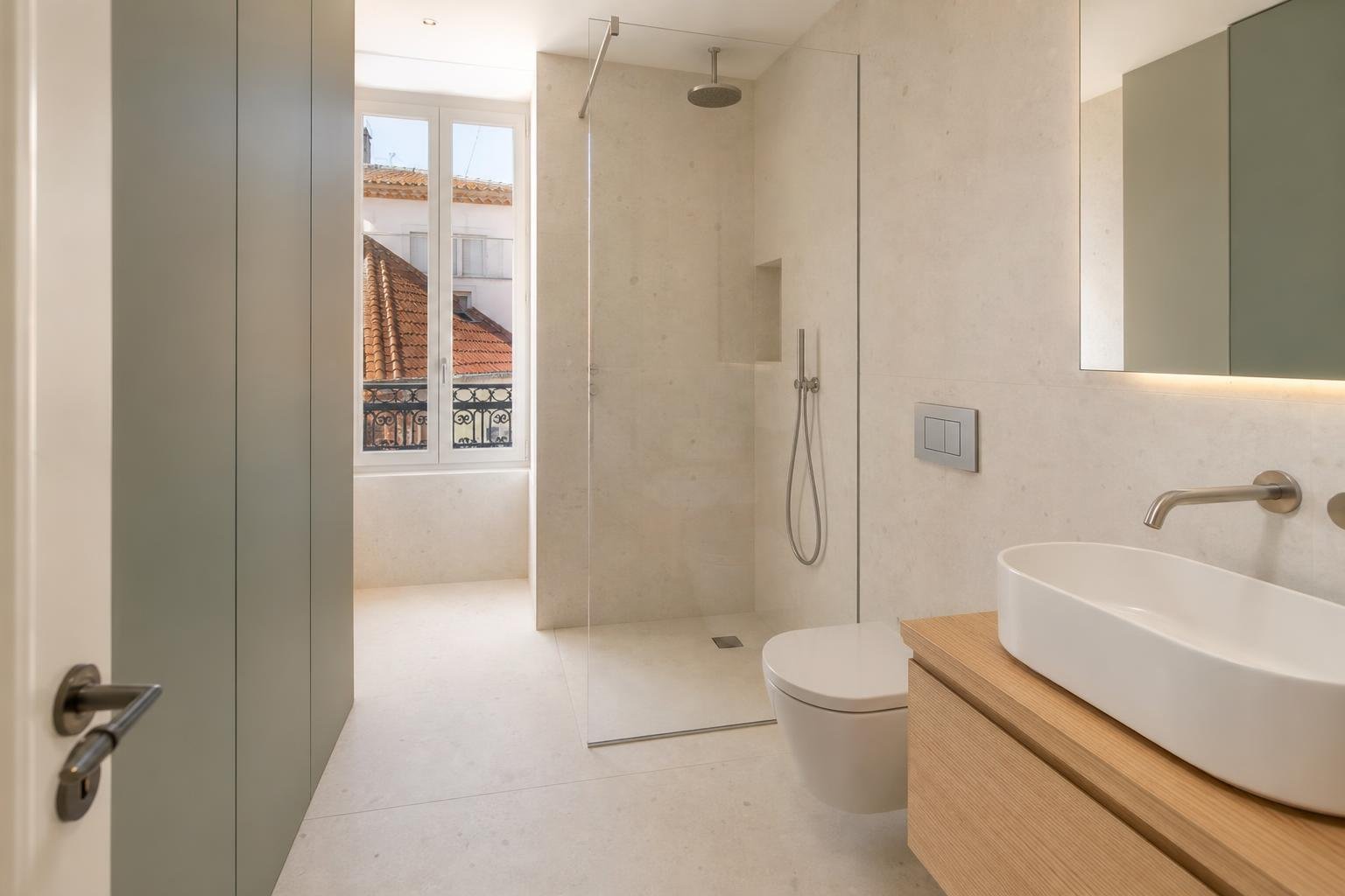 Casa de banho renovada num apartamento de Lisboa com duche, torneira eficiente e autoclismo de dupla descarga.