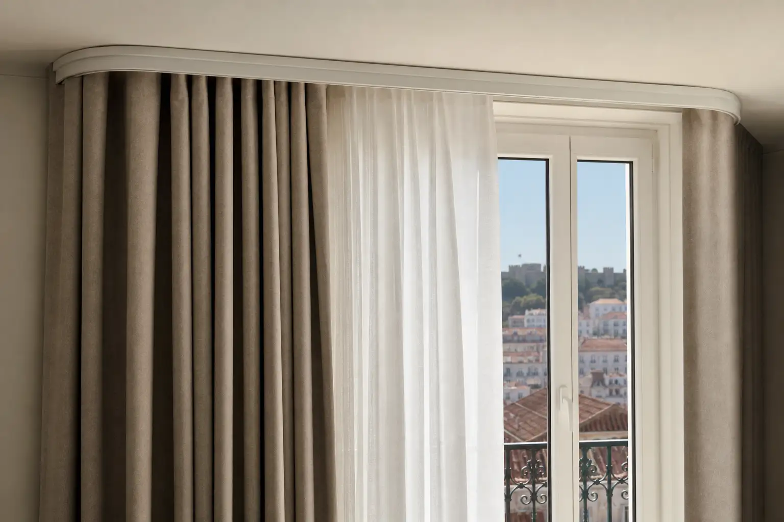 Pormenor de calha e cortina térmica bem ajustada numa janela de apartamento.