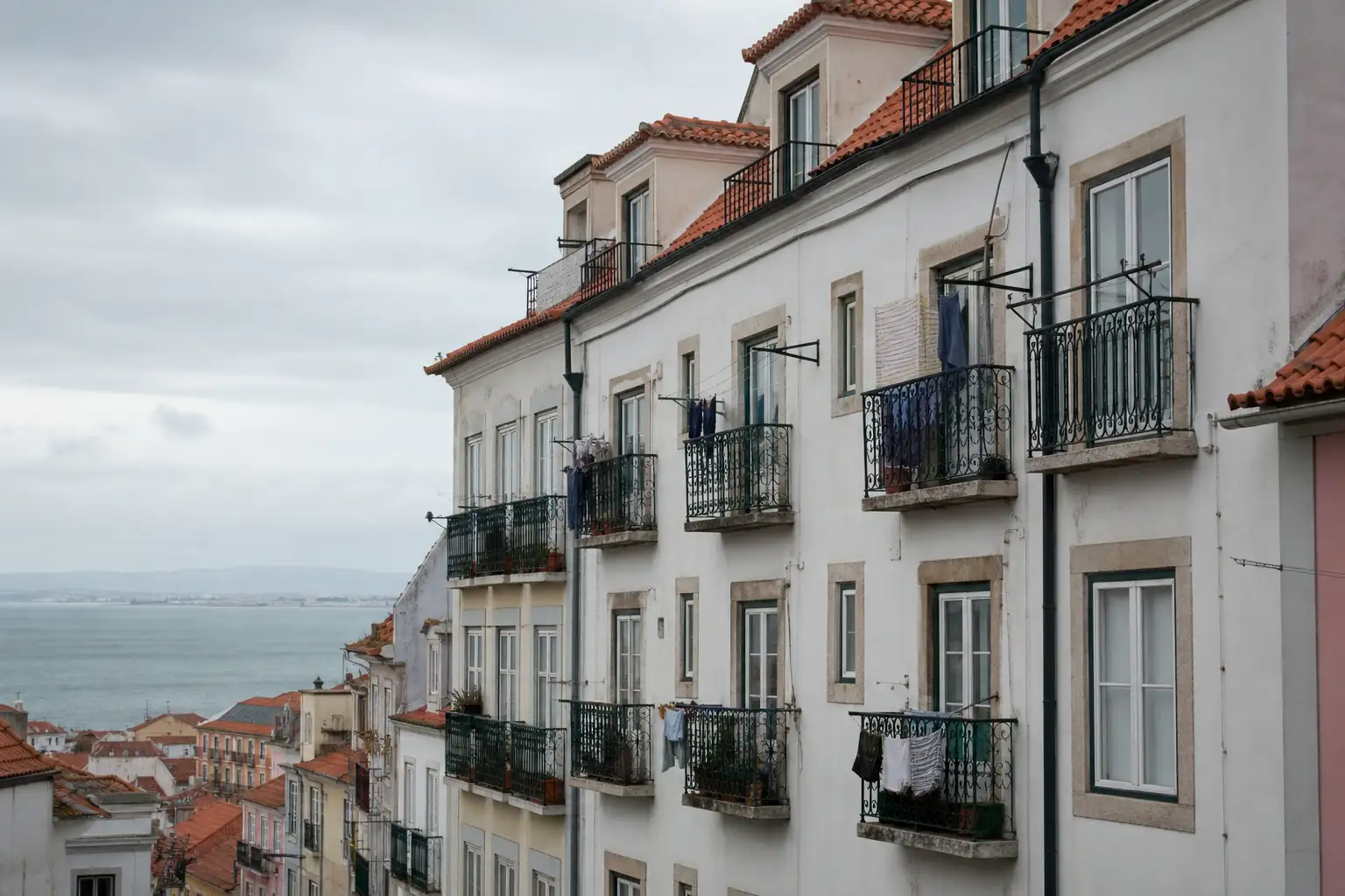 Fachada residencial de Lisboa com varandas e soluções discretas para secar roupa no exterior.