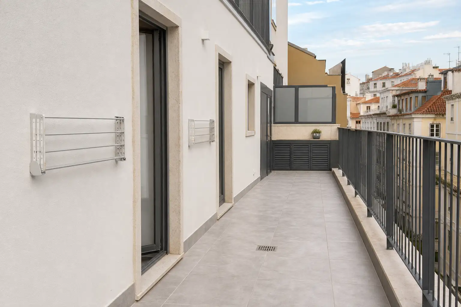 Detail of drained paving and fold-away clotheslines on a shared residential rooftop