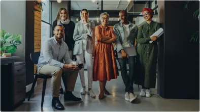 A diverse group of professionals standing together in an office, symbolizing commitment to inclusion at intive. 