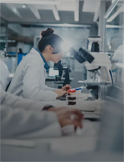 A team of scientists in lab coats focused on their computers in a modern laboratory setting.