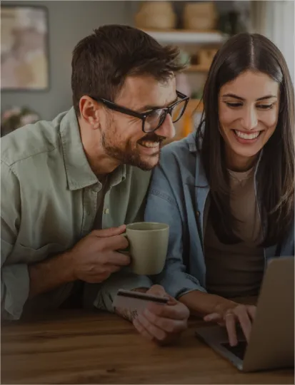 A couple engages with a laptop, sharing the Rossmann shopping experience in a comfortable and inviting environment.