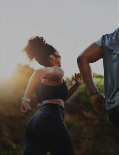 A man and woman running together in sunlight, symbolizing vitality and the spirit of Intersport retail transformation.