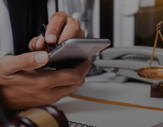 A suited man uses his smartphone appearing engaged and attentive in a business setting.