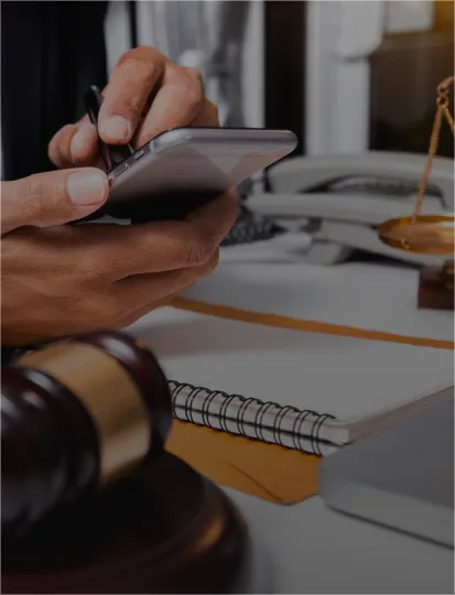 A suited man uses his smartphone appearing engaged and attentive in a business setting.