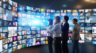 People focused on multiple television screens, each displaying a diverse array of images in a shared viewing space.