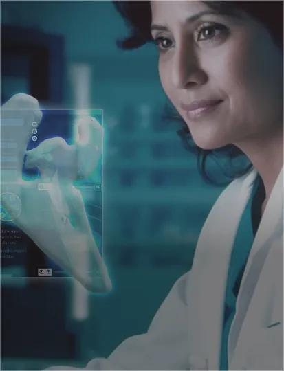 A woman in a lab coat analyzes information displayed on a screen in a research laboratory.
