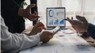 Business professionals analyzing data charts and financial graphs during a strategy meeting, illustrating how data-driven decision-making supports financial performance.