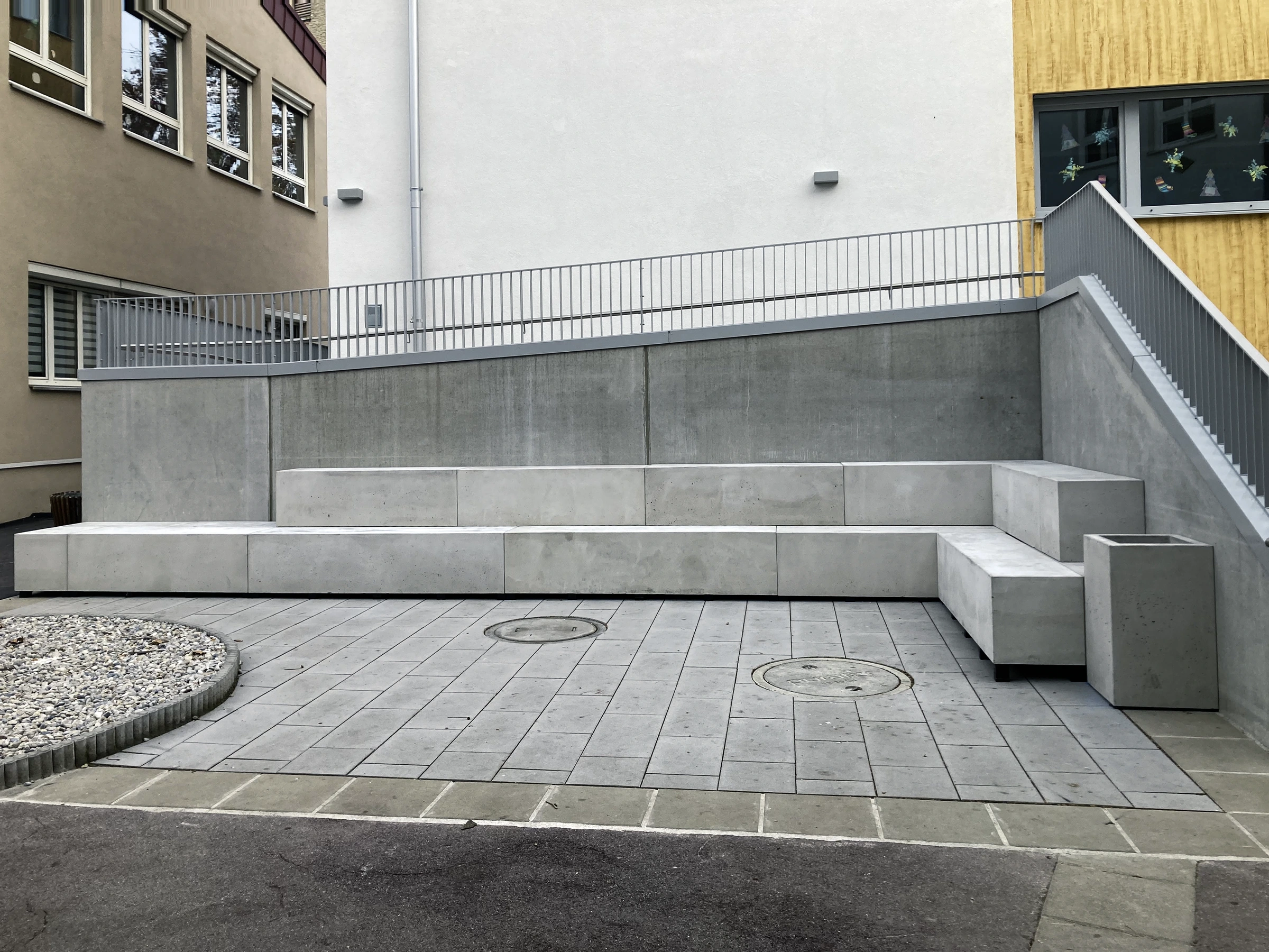 Eine abgestufte Sitzlandschaft aus Beton auf einem Schulhof