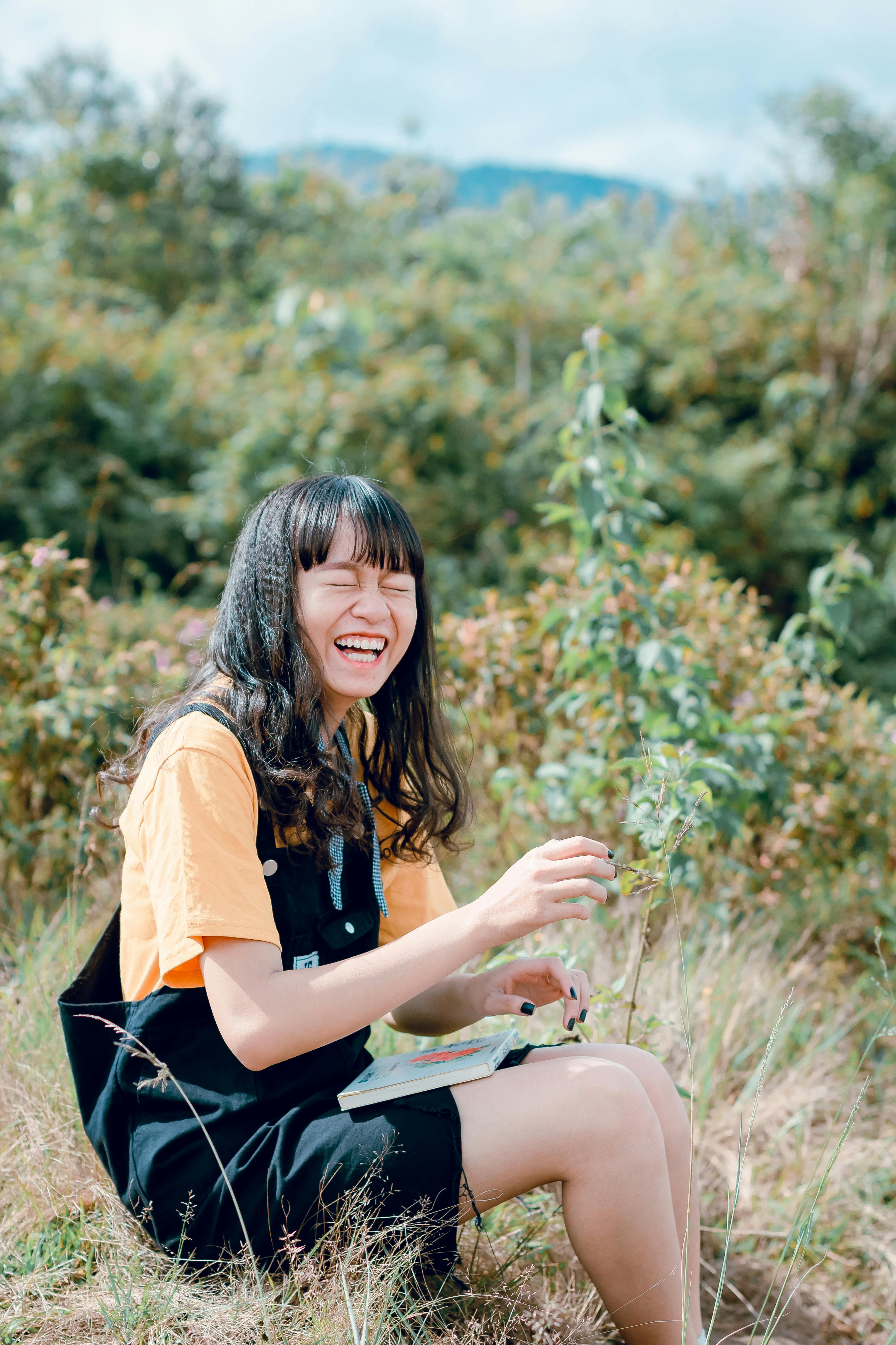 Person laughing in natural light, representing the joy and playfulness of authentic adult friendship and emotional well-being in Port Moody, BC.