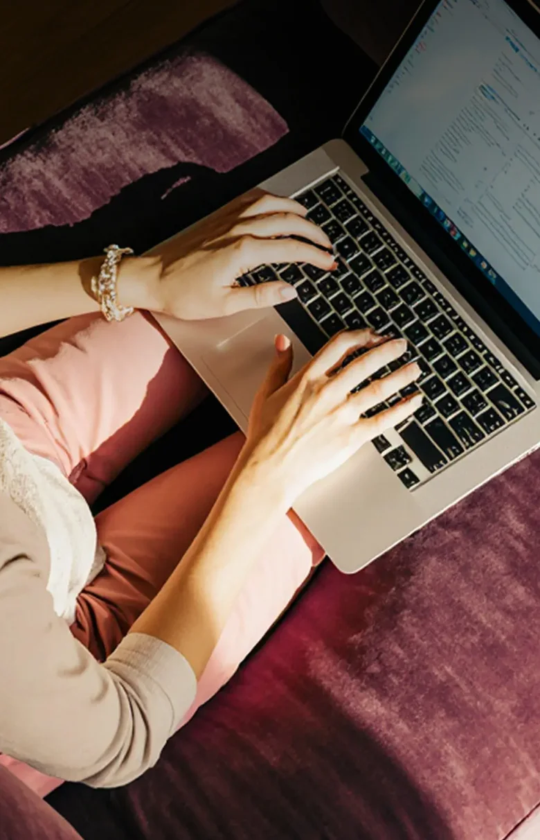 Content creation and social media management showcase featuring a designer working on a laptop with a purple brand aesthetic.