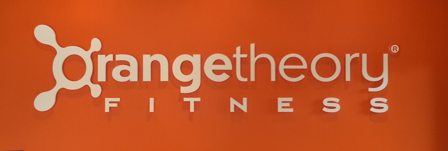 OrangeTheory Fitness logo with stylized orange molecule graphic on an orange background.