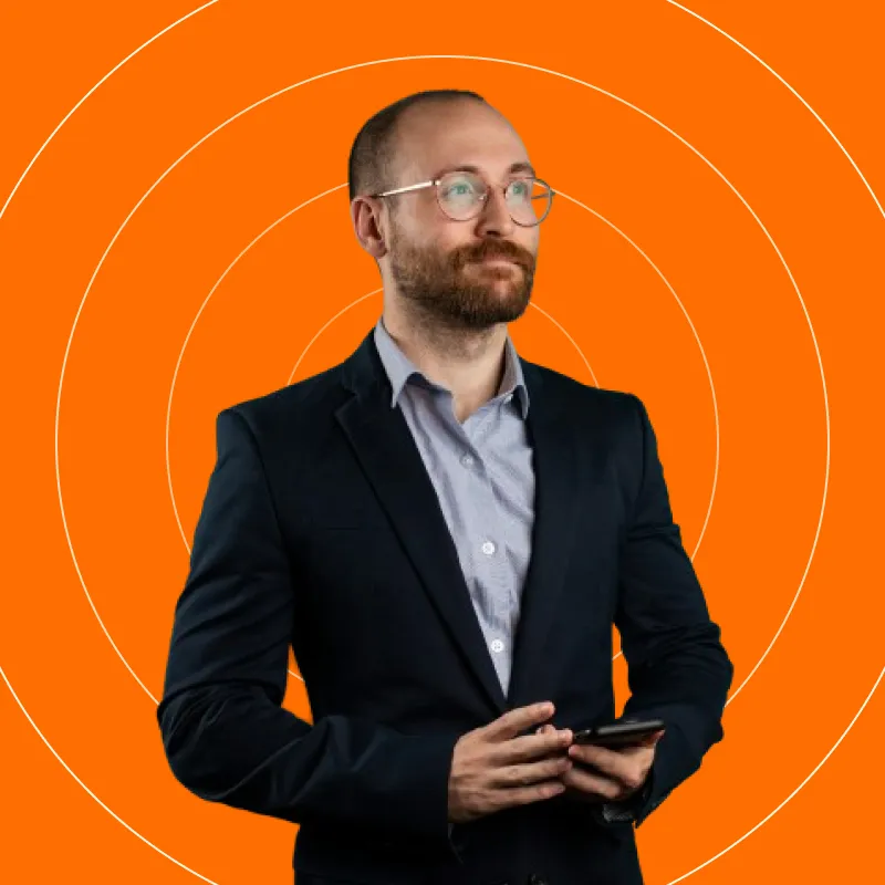 A man in a suit is holding a cell phone.
