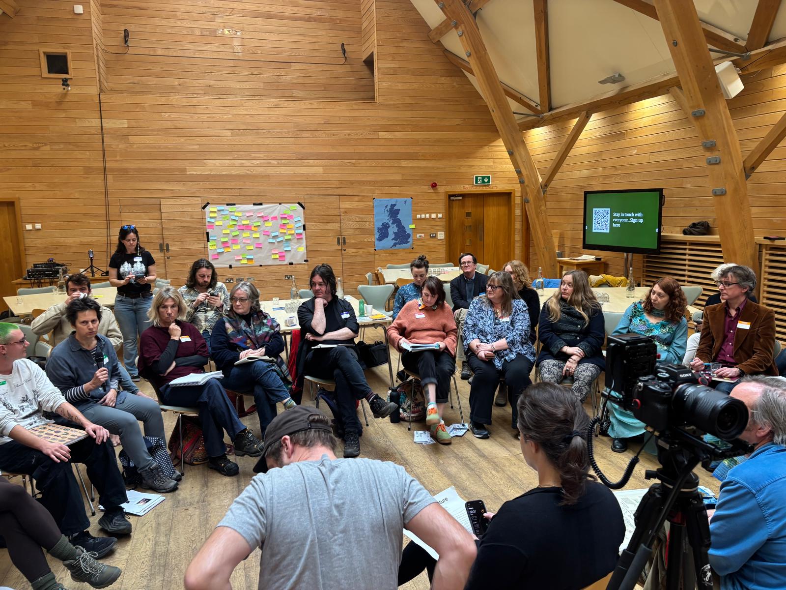 Photograph of a group of people sitting in a circle mid discussion