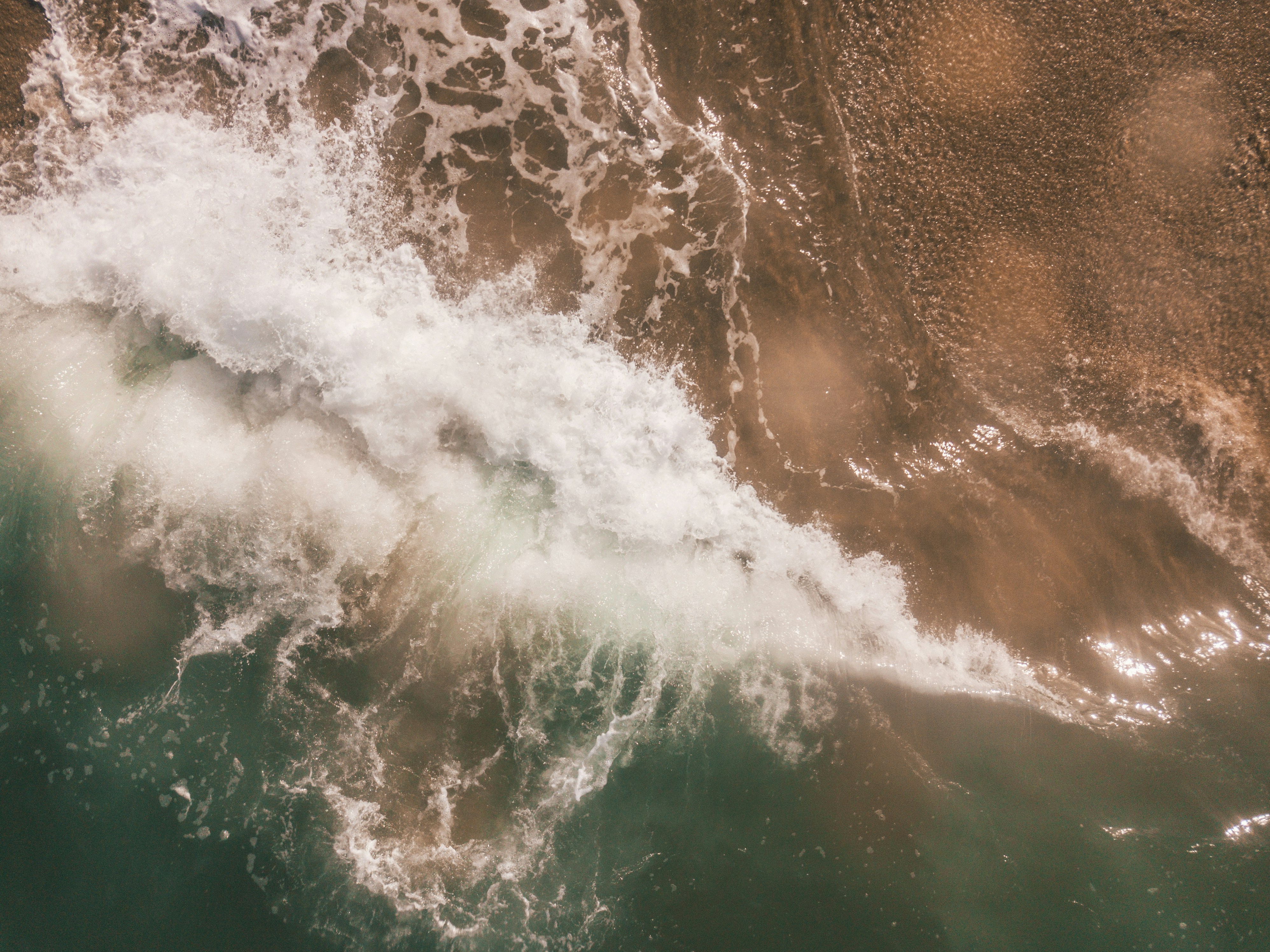 Wave hitting sandy shore. 