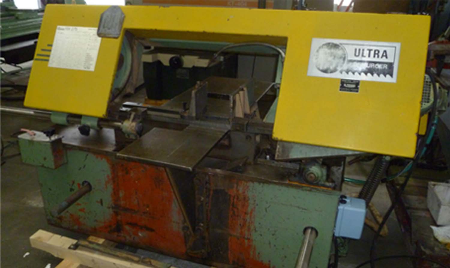 Scie à ruban industrielle Ultra avec capot jaune dans un atelier mécanique