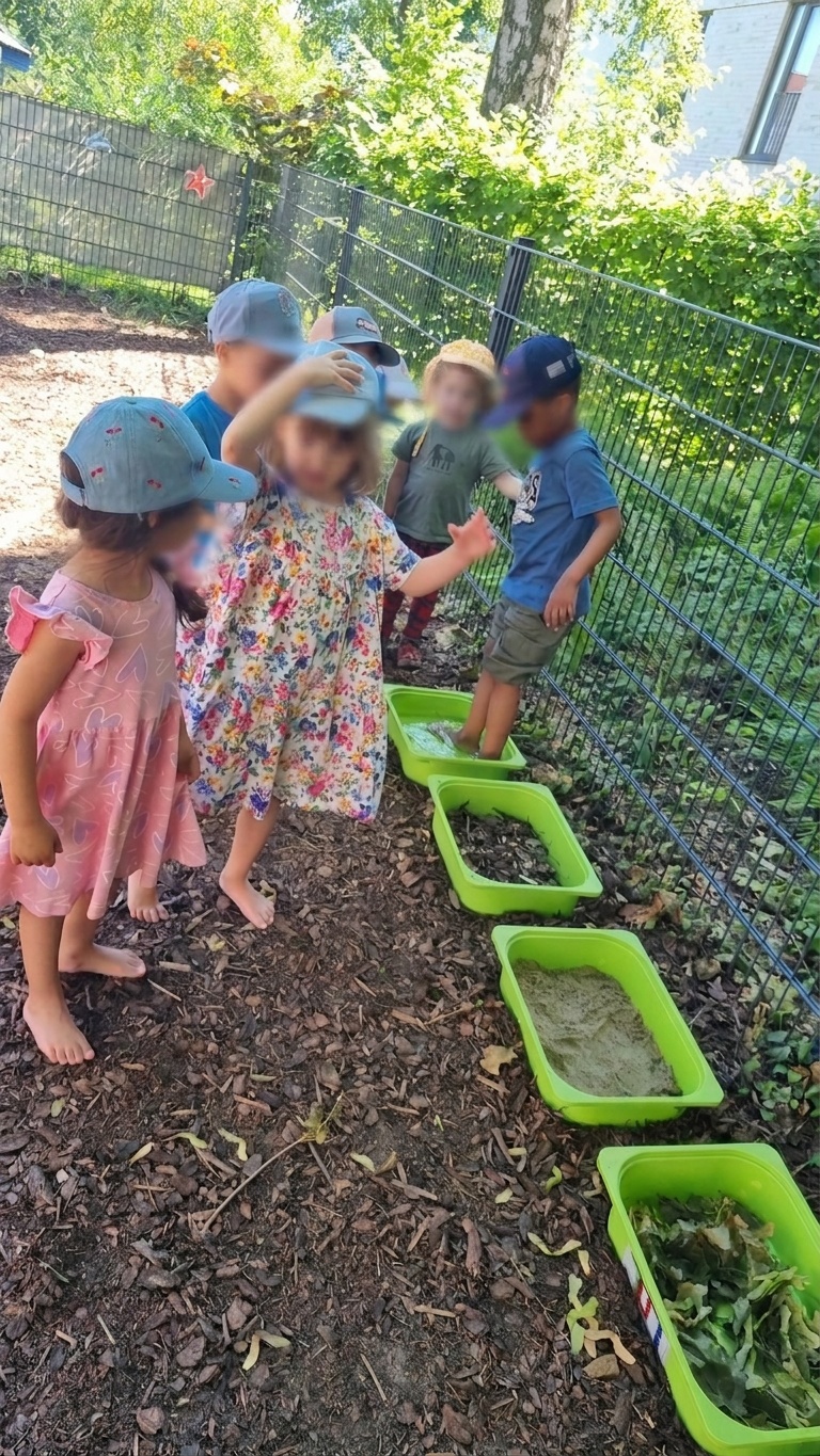 Kinder der elbzwerge Kita Stellingen gehen barfuß durch die grünen Wannen im Garten