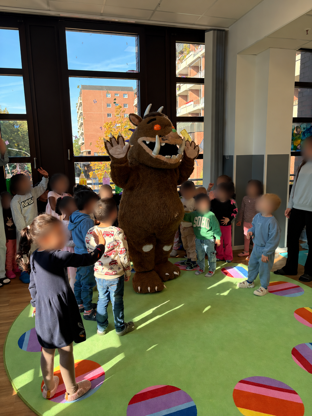 Der Grüffelo steht auf dem grünen Teppich, Kinder der elbzwerge Kita Rahlstedt im Kreis darum