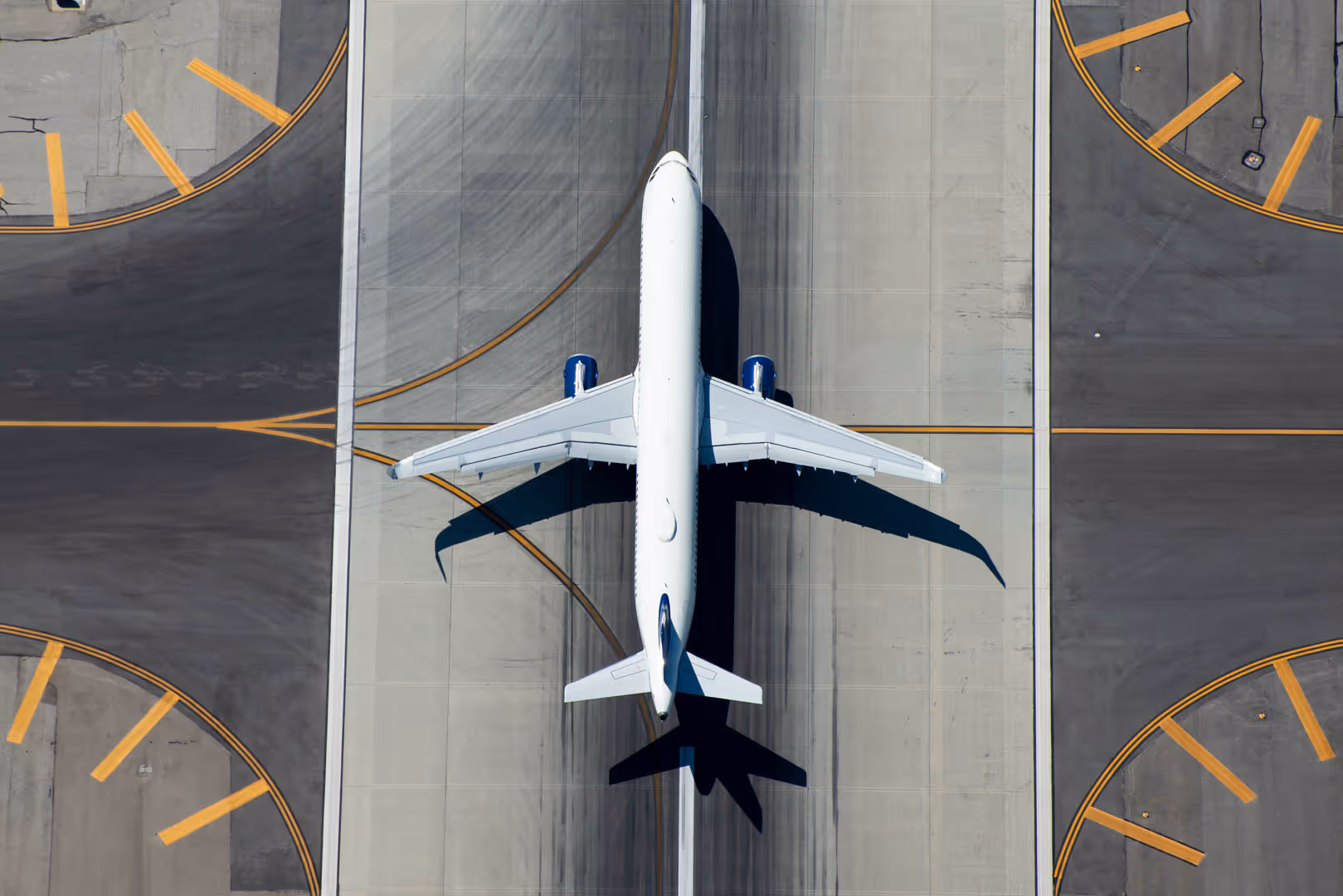 A stationary plane on an airport runway intersection.