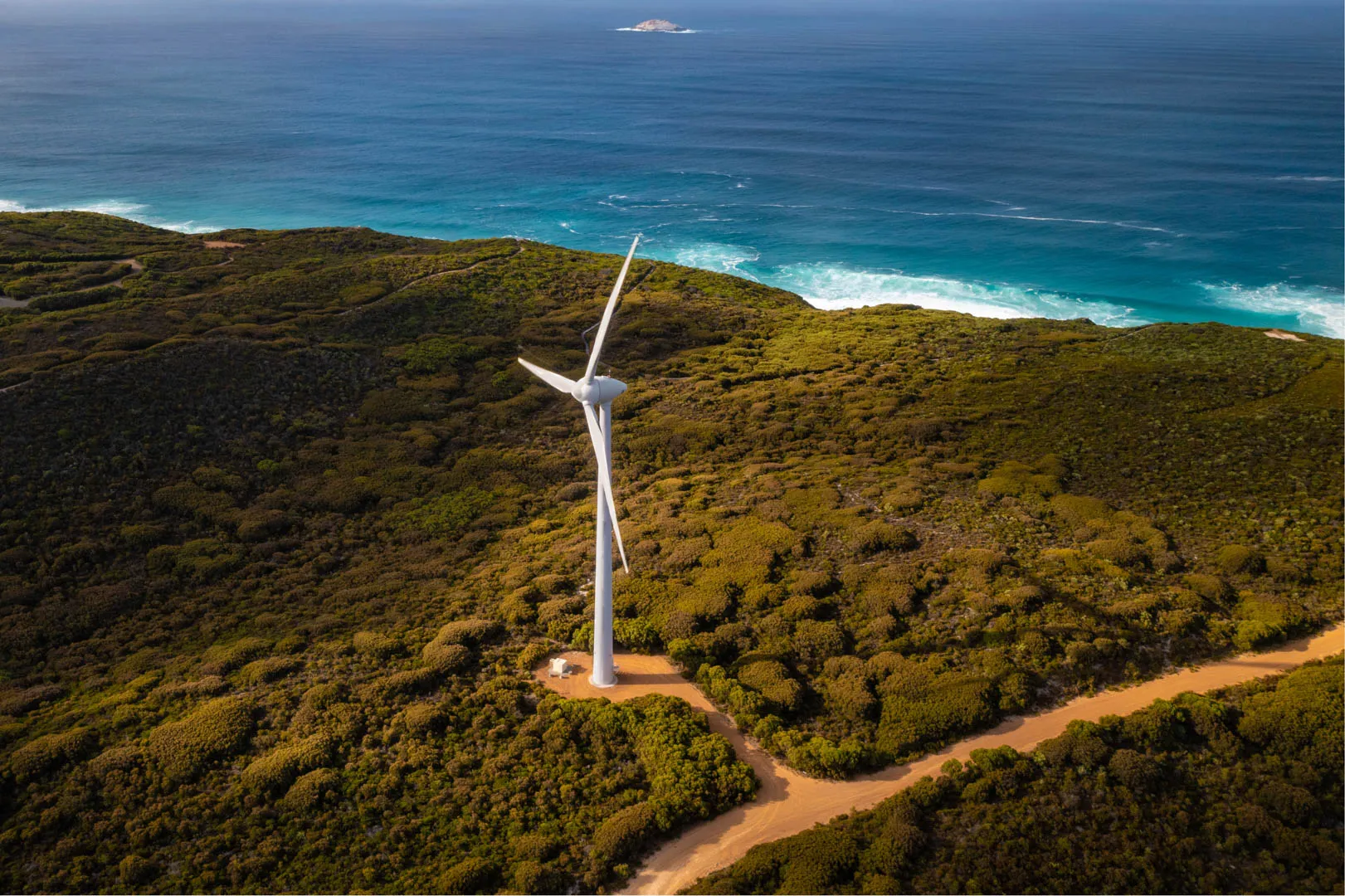 A windmill next to an unsealed road along the Australian Coastline.