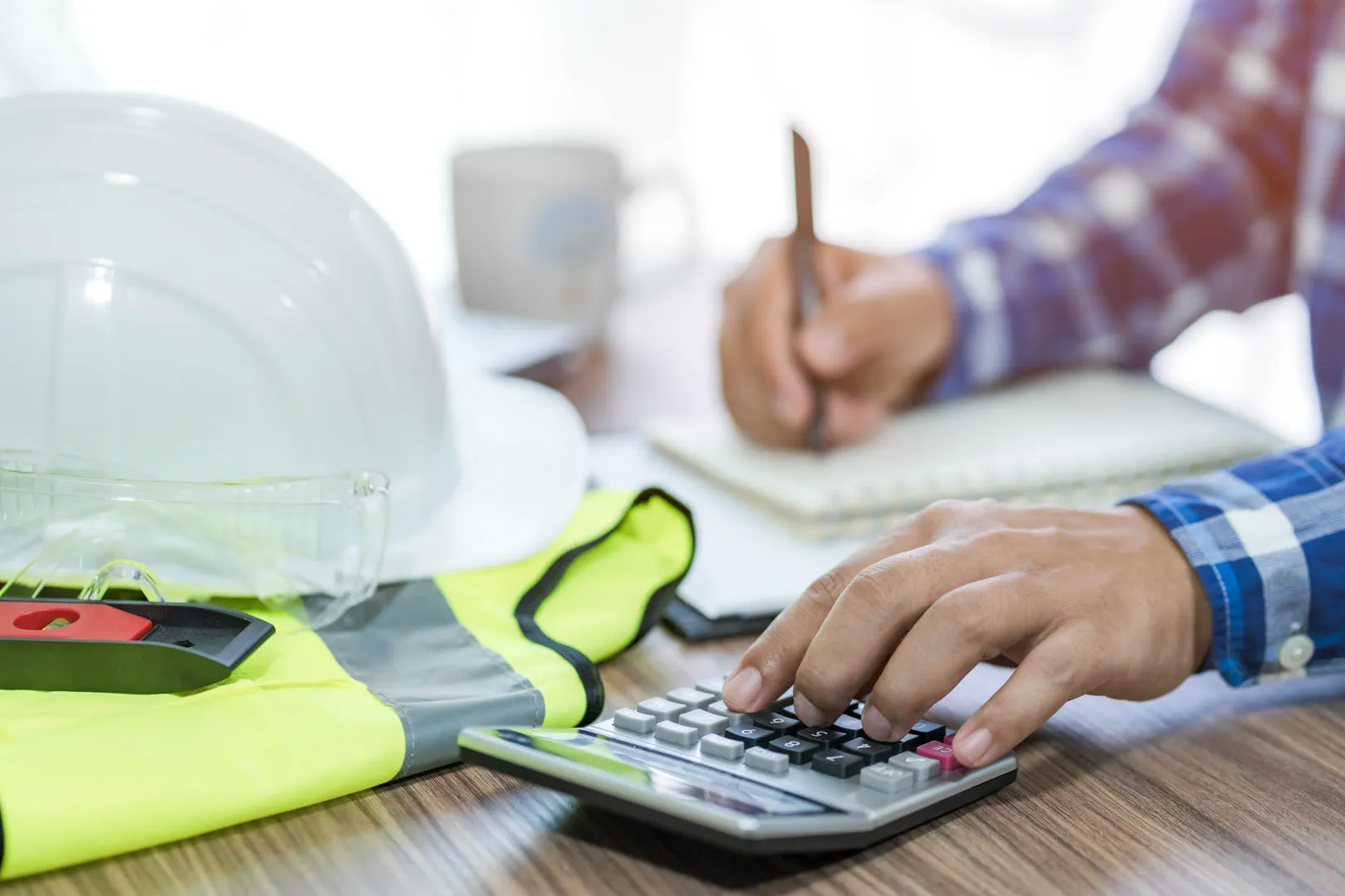 A construction worker at a desk doing paperwork.