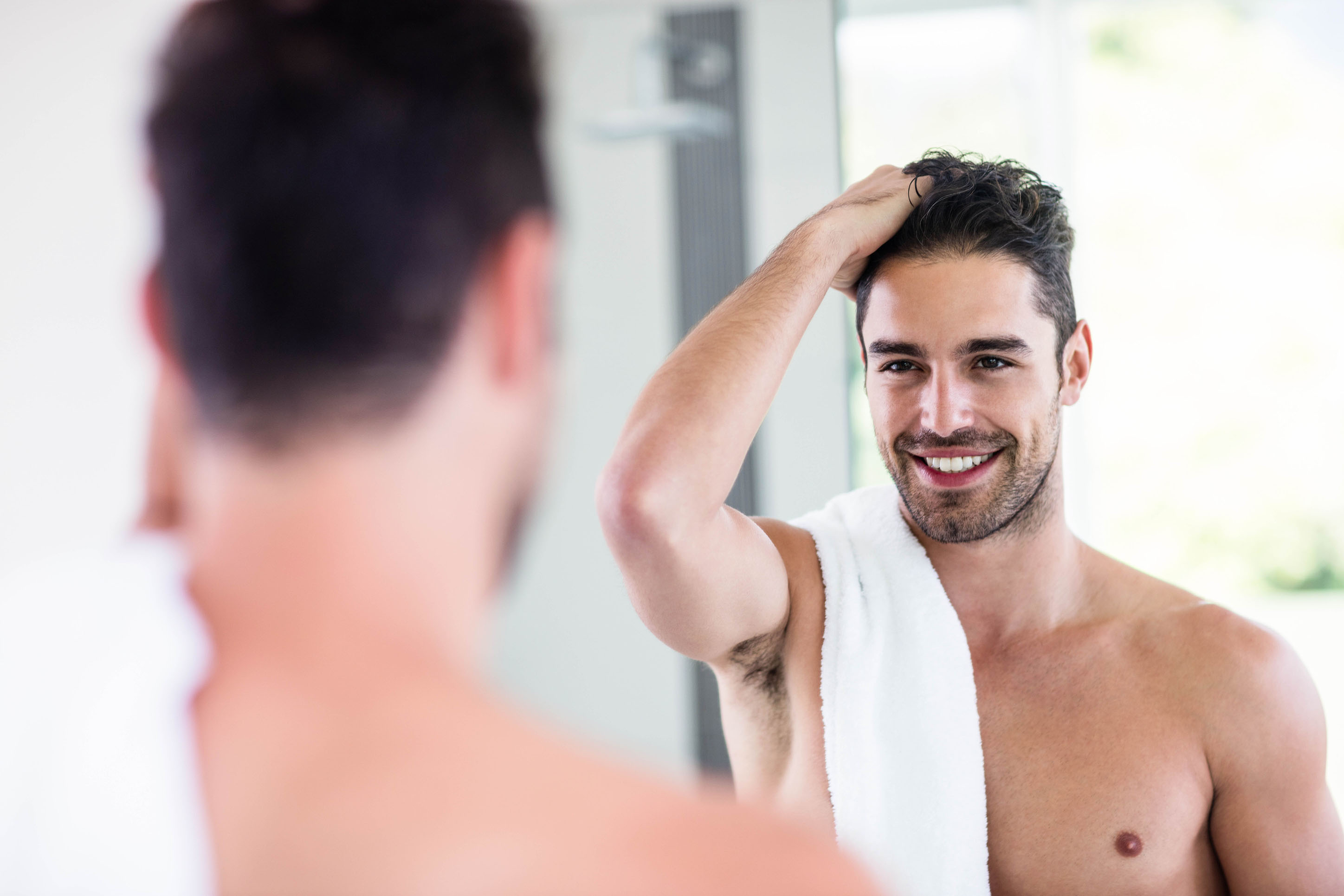 Man looking at his hair in the mirror