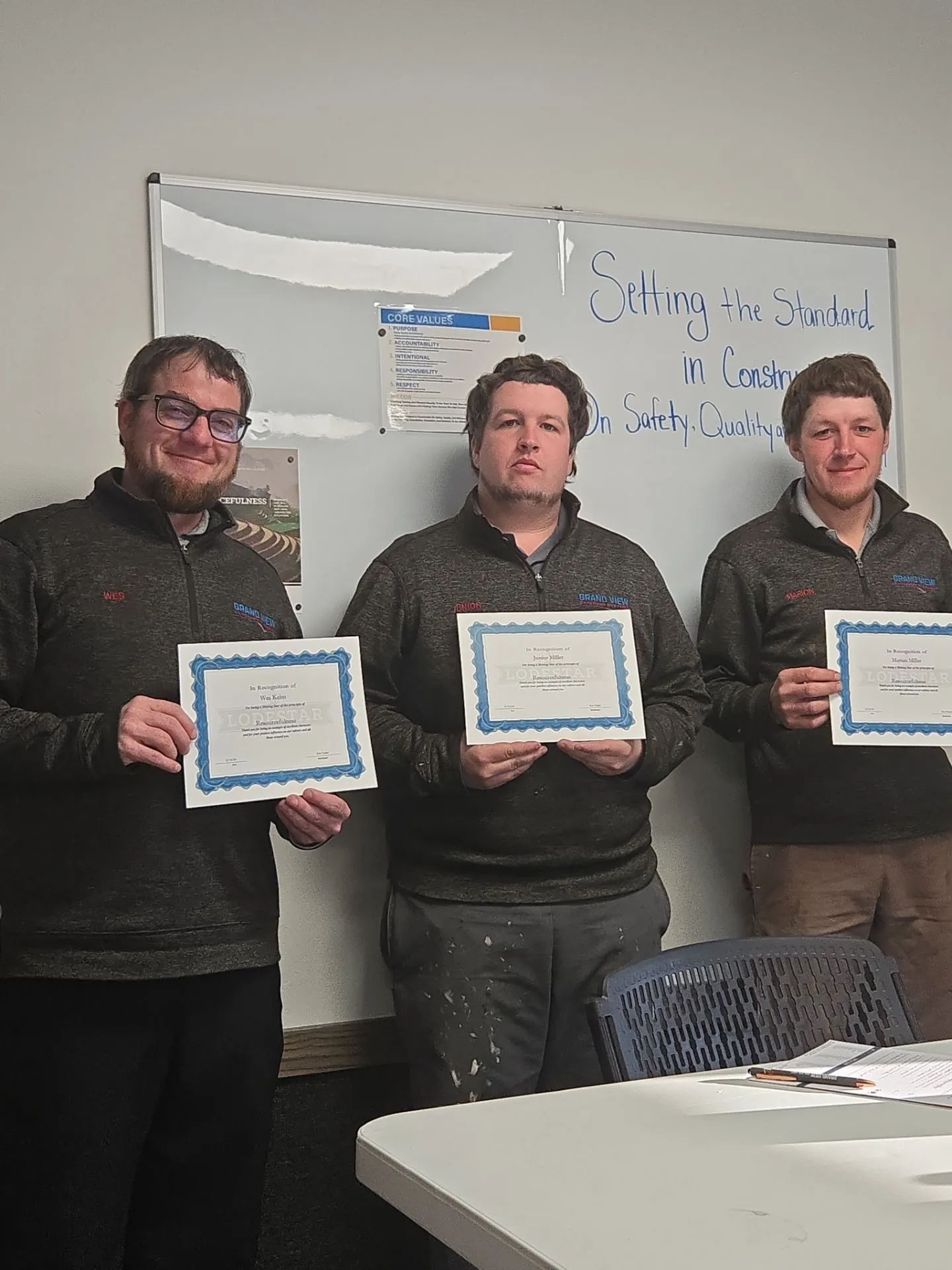 Wes Keim, Junior Miller, and Marion Miller standing next to eachother holding their character of the month awards