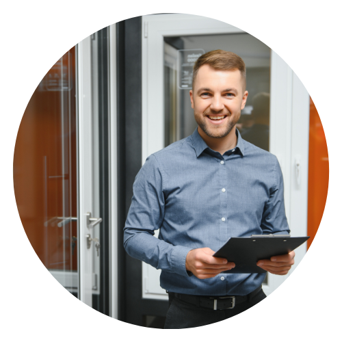 Glücklicher Fensterbauer dunkelhaariger Mann mit Brille und Arbeitskleidung in Fensterbaubetrieb Joulee Foerderservice Sanierungsfoerderung