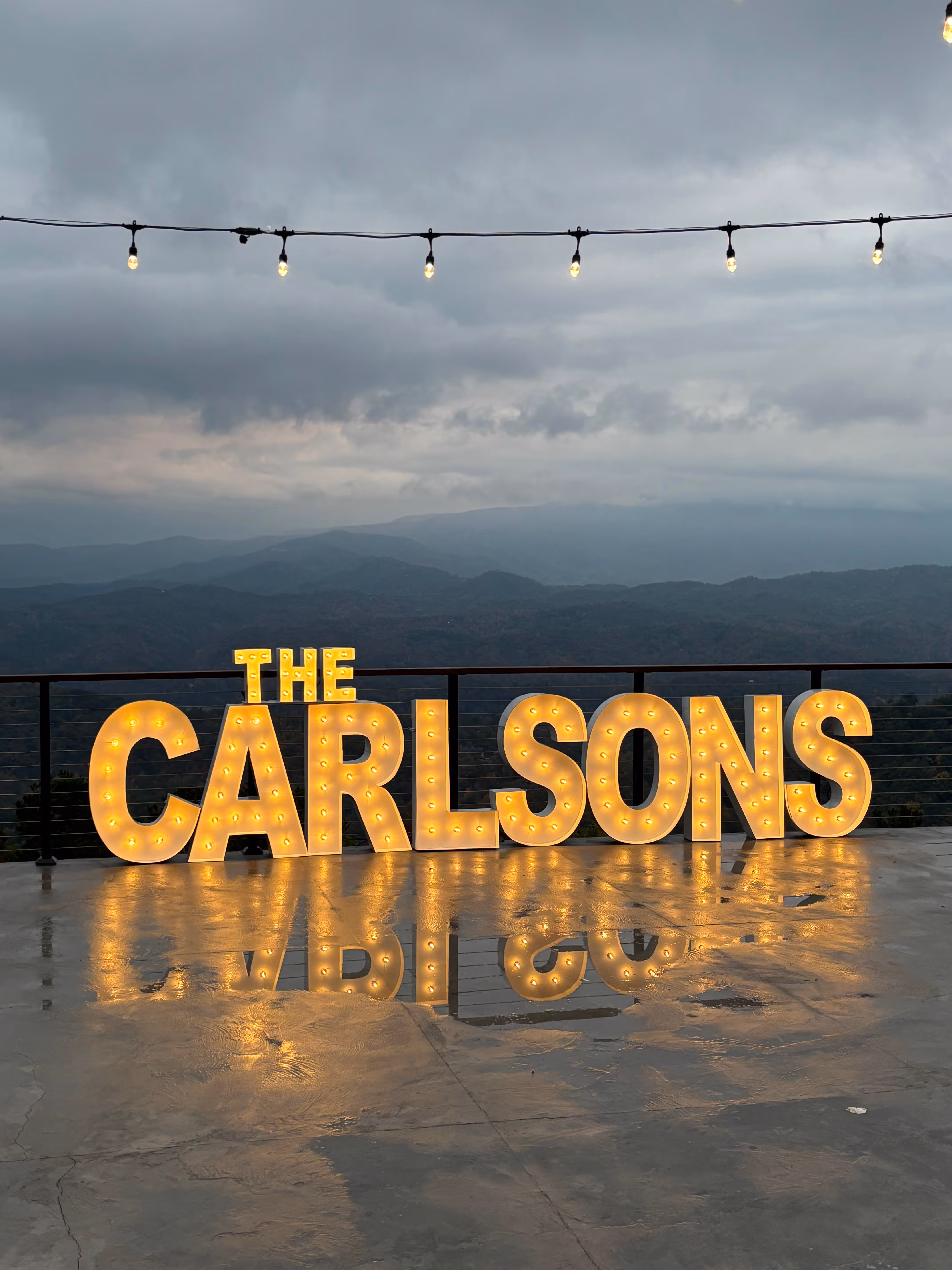 Lit letters spelling HVMS in front of silver and blue balloons at Hardin Valley Middle School with mural stars and music notes on the wall.