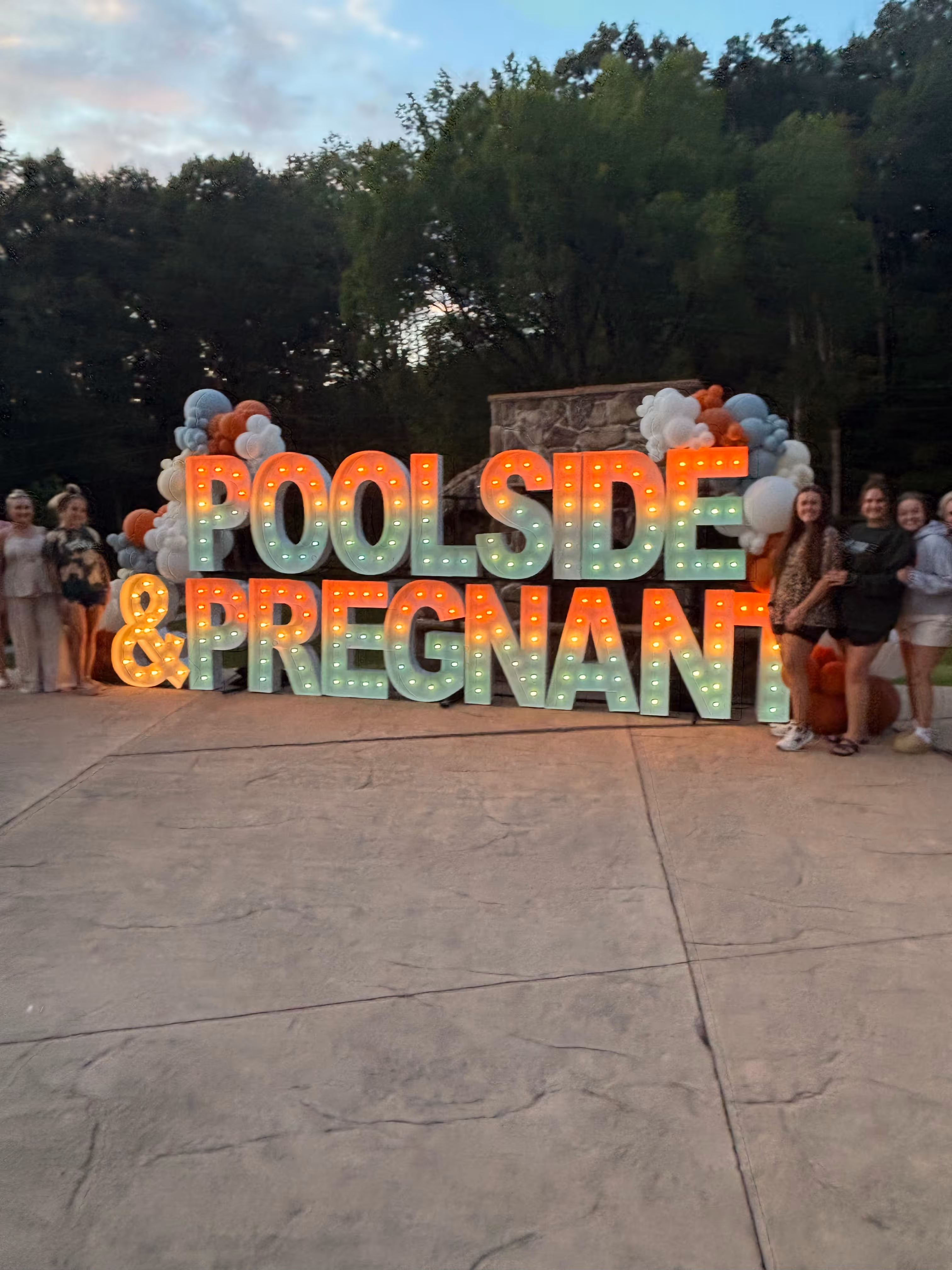 Lit letters spelling HVMS in front of silver and blue balloons at Hardin Valley Middle School with mural stars and music notes on the wall.