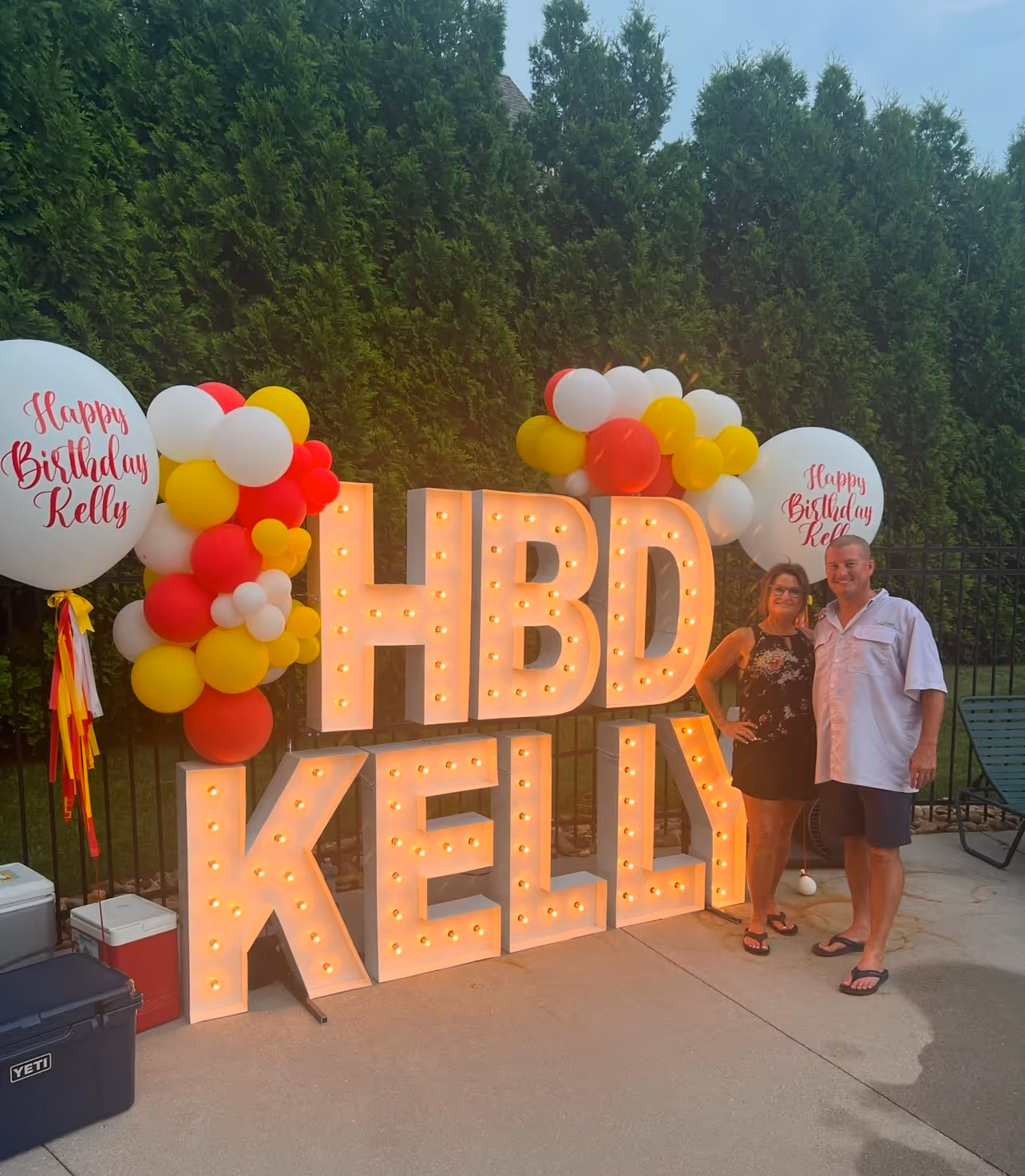Lit letters spelling HVMS in front of silver and blue balloons at Hardin Valley Middle School with mural stars and music notes on the wall.