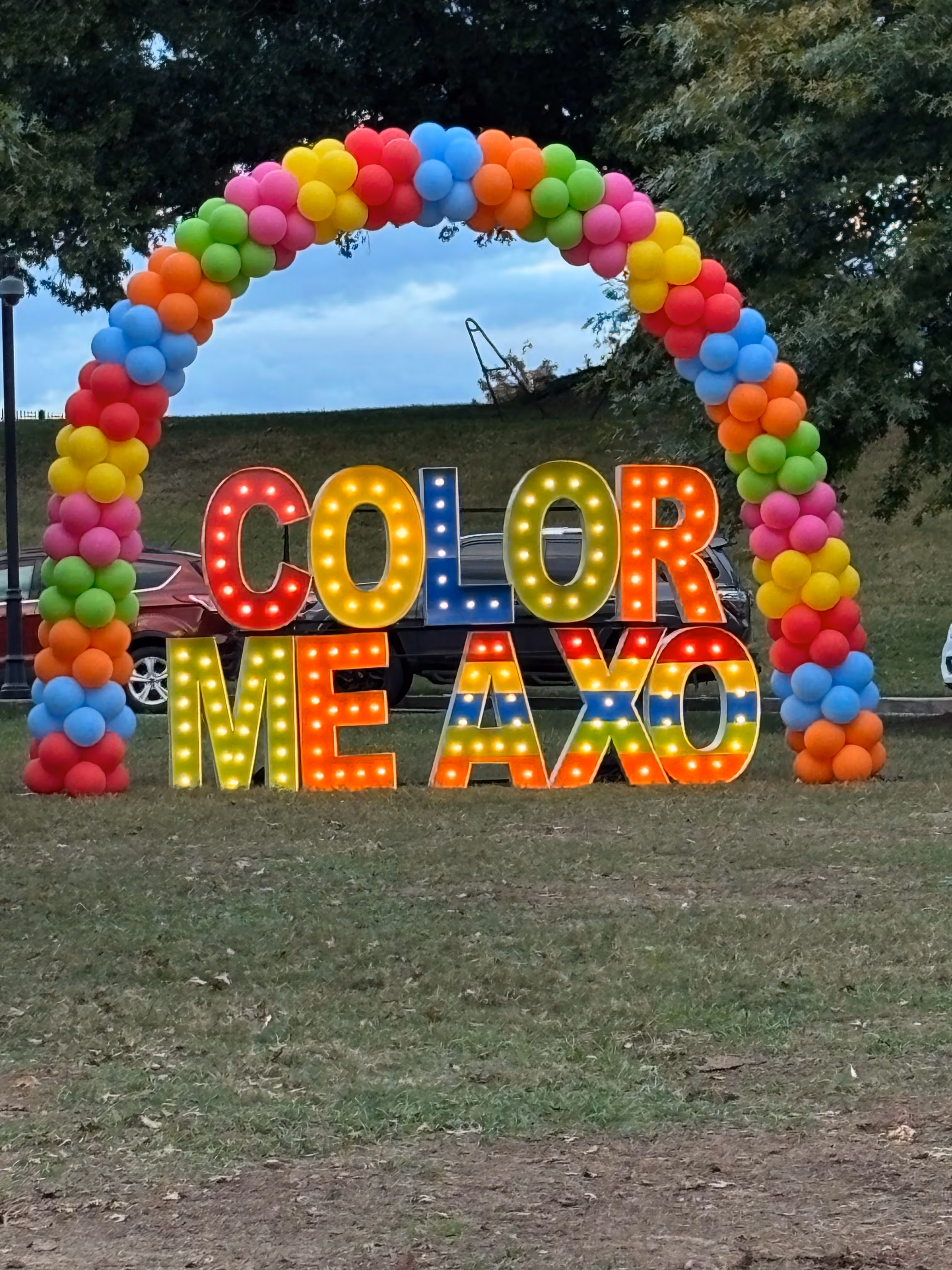 Lit letters spelling HVMS in front of silver and blue balloons at Hardin Valley Middle School with mural stars and music notes on the wall.