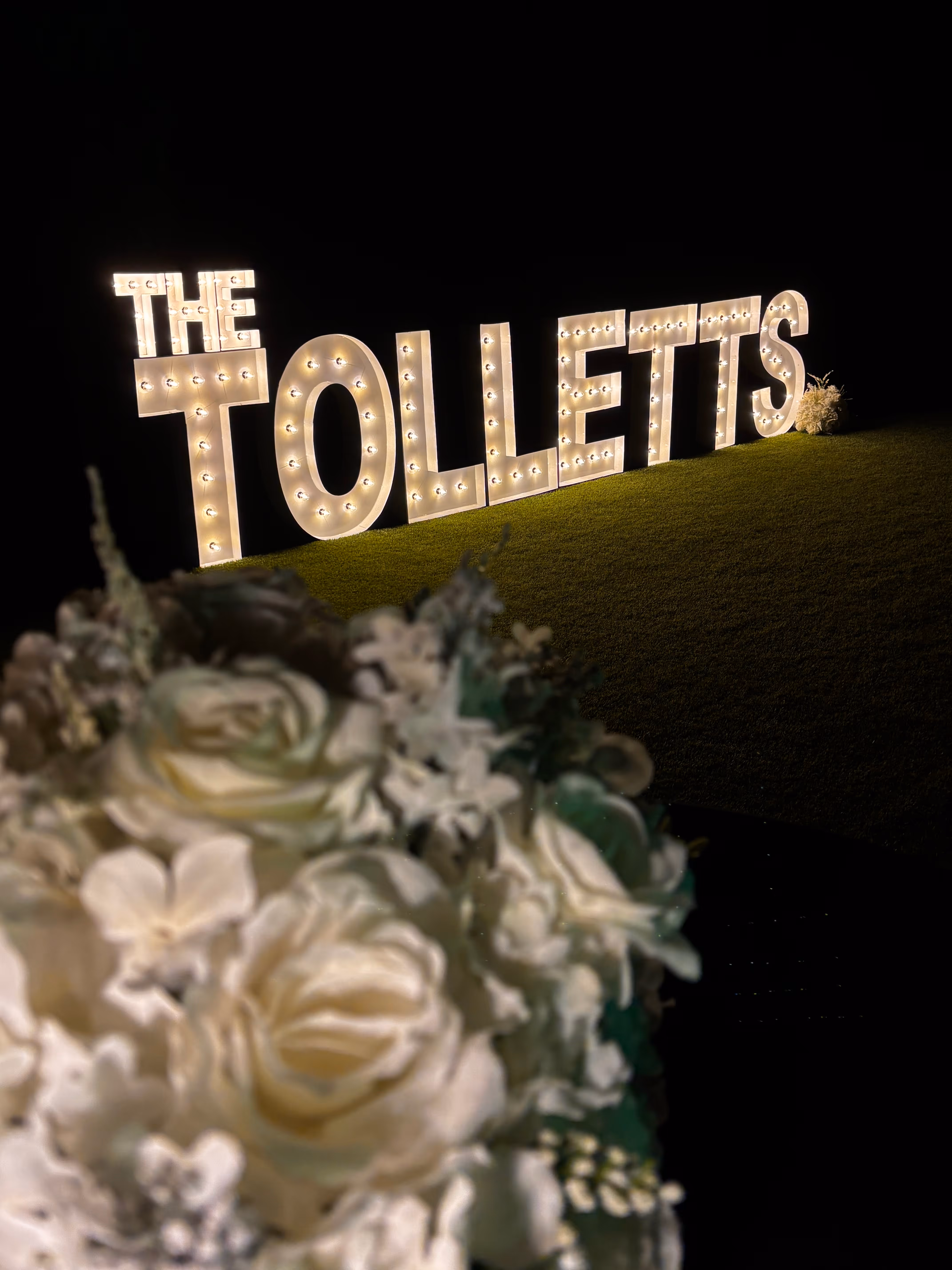 Lit letters spelling HVMS in front of silver and blue balloons at Hardin Valley Middle School with mural stars and music notes on the wall.