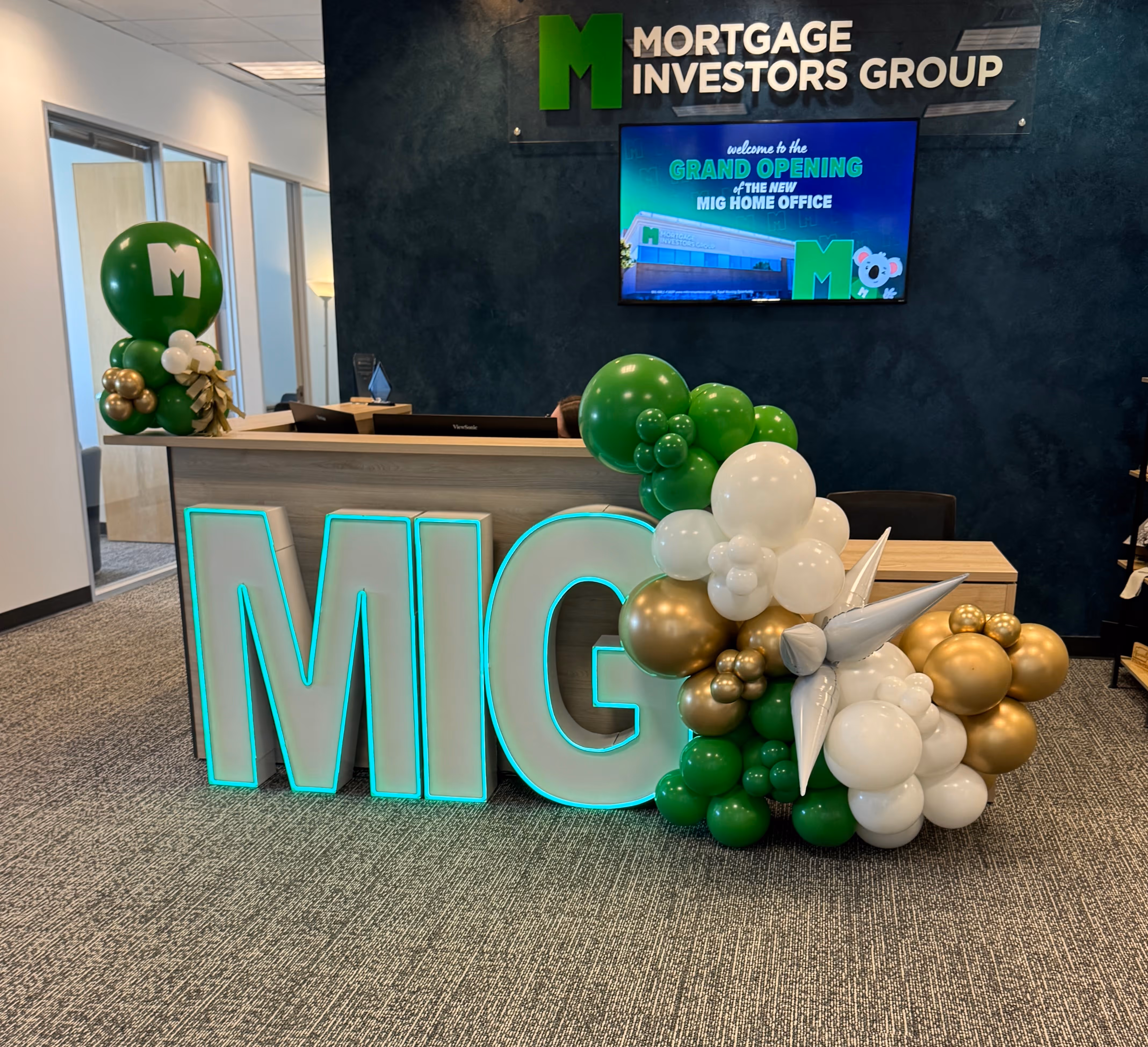 Lit letters spelling HVMS in front of silver and blue balloons at Hardin Valley Middle School with mural stars and music notes on the wall.
