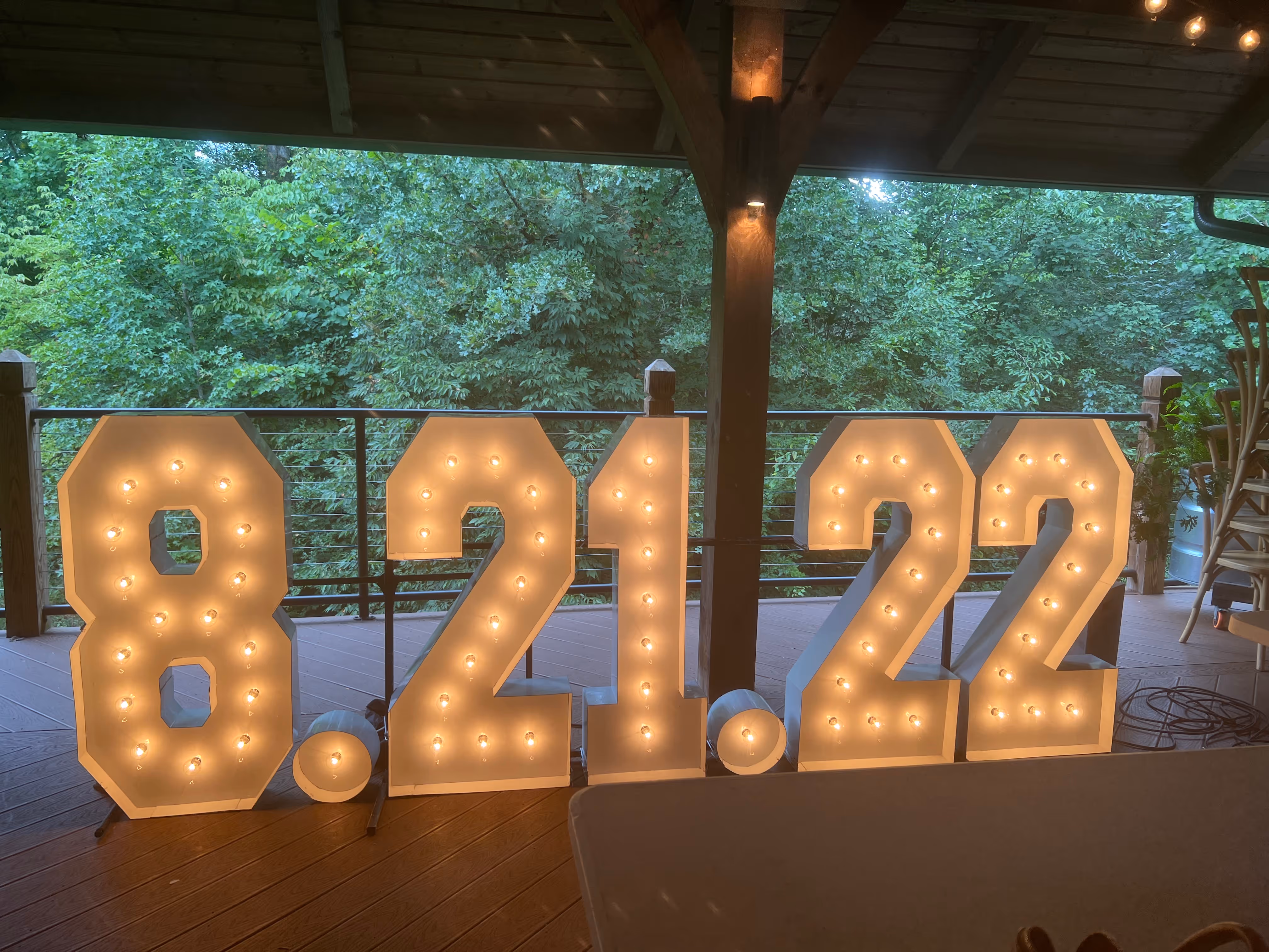 Lit letters spelling HVMS in front of silver and blue balloons at Hardin Valley Middle School with mural stars and music notes on the wall.