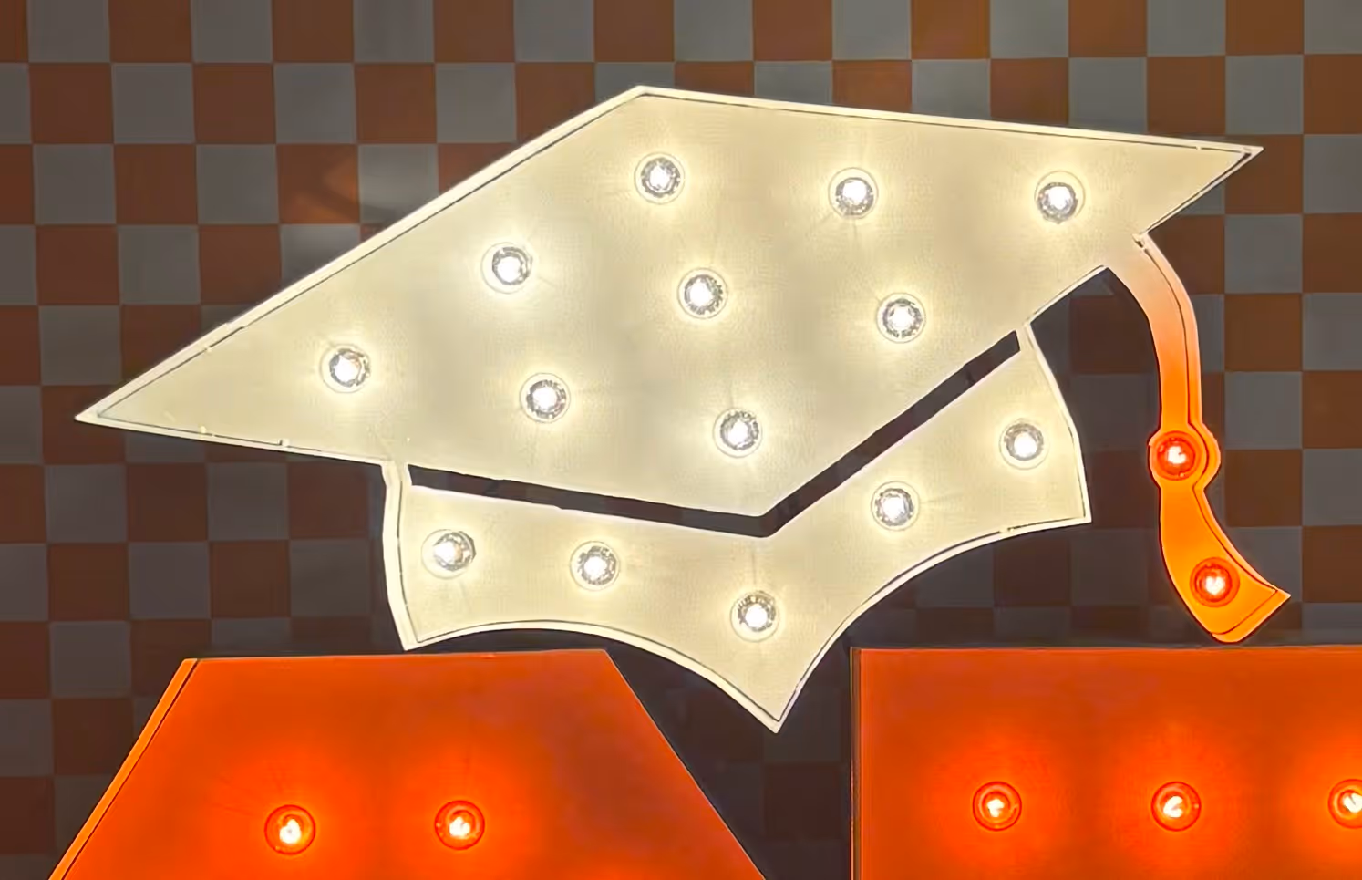 Lit letters spelling HVMS in front of silver and blue balloons at Hardin Valley Middle School with mural stars and music notes on the wall.