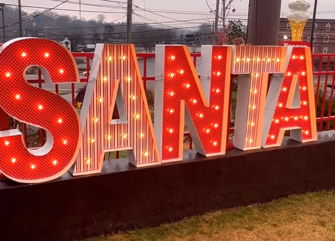 Lit letters spelling HVMS in front of silver and blue balloons at Hardin Valley Middle School with mural stars and music notes on the wall.